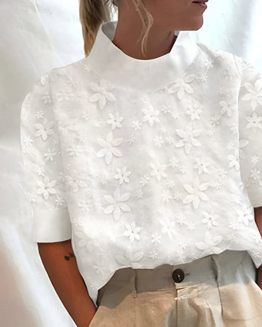 Blusa elegante con cuello alto amplio y diseño moderno